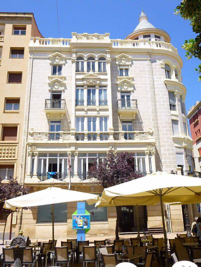Edificio ecléctico de esquina en la calle Portales, con miradores, balcones de forja y un torreón con chapitel