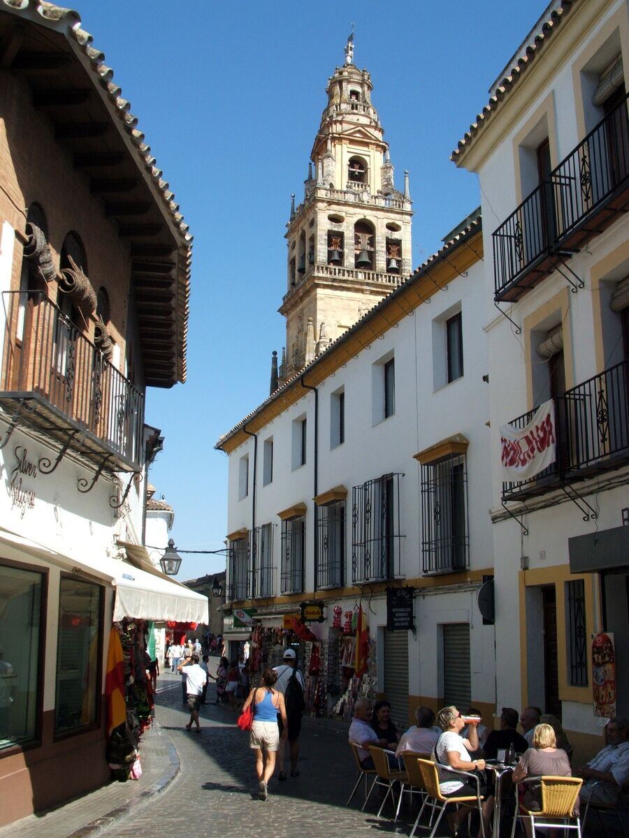 Calle de la Judería de Córdoba con la torre de la Mezquita al fondo y terrazas